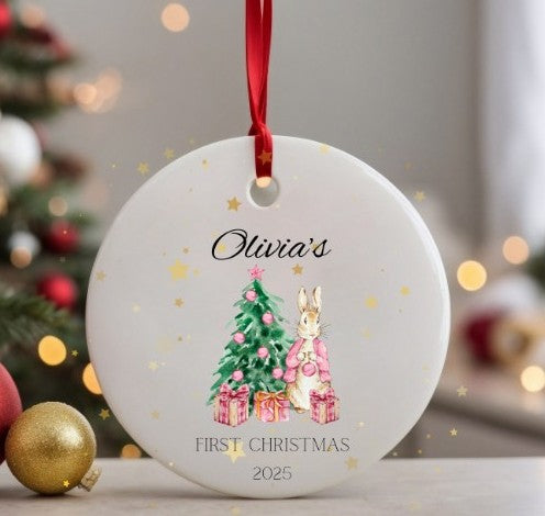Personalised Christmas ornament with a rabbit and tree design, featuring 'Olivia's First Christmas 2025' text.