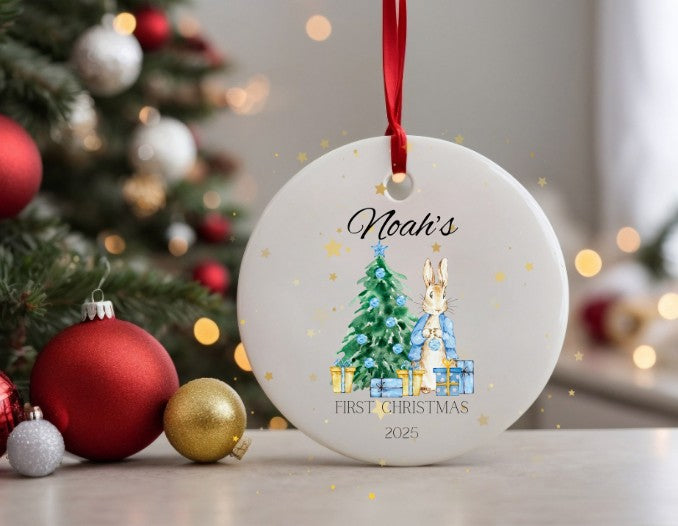 Personalised Christmas ornament with a rabbit and tree design, placed in front of a decorated Christmas tree.