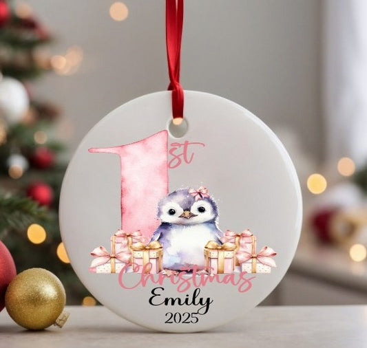 Decorative Christmas ornament with a penguin and gift boxes, featuring '1st Christmas Emily 2025' text.
