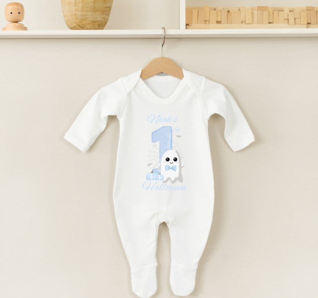 White baby onesie with blue design and text on a beige wall