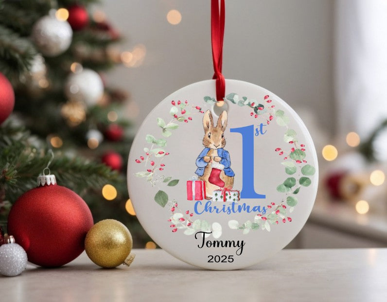 Personalised Christmas ornament with a rabbit design and text, placed in front of a decorated Christmas tree.