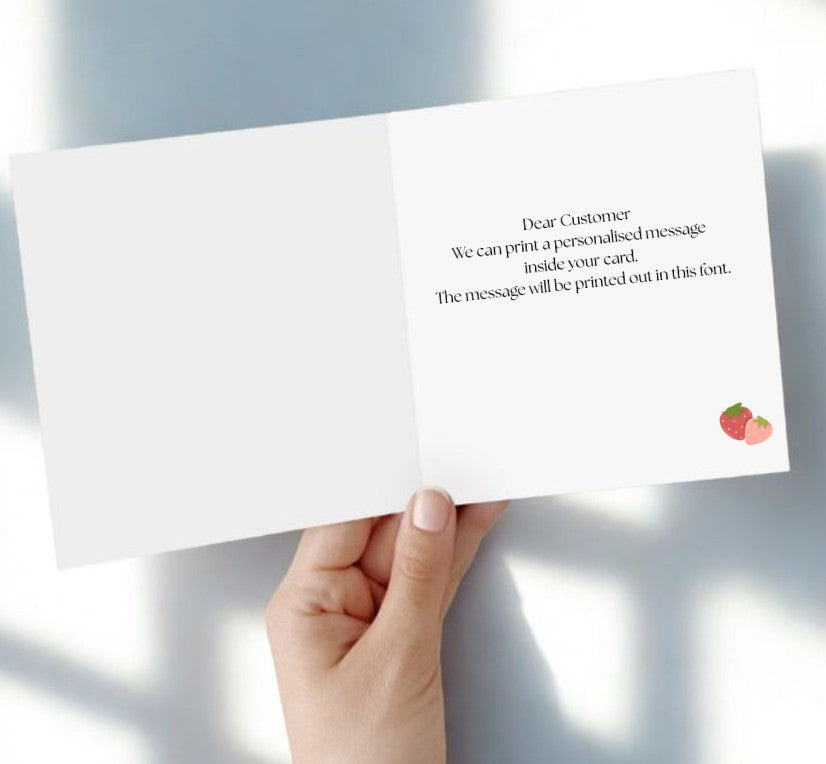 Hand holding a greeting card with text and a brand logo on a light background