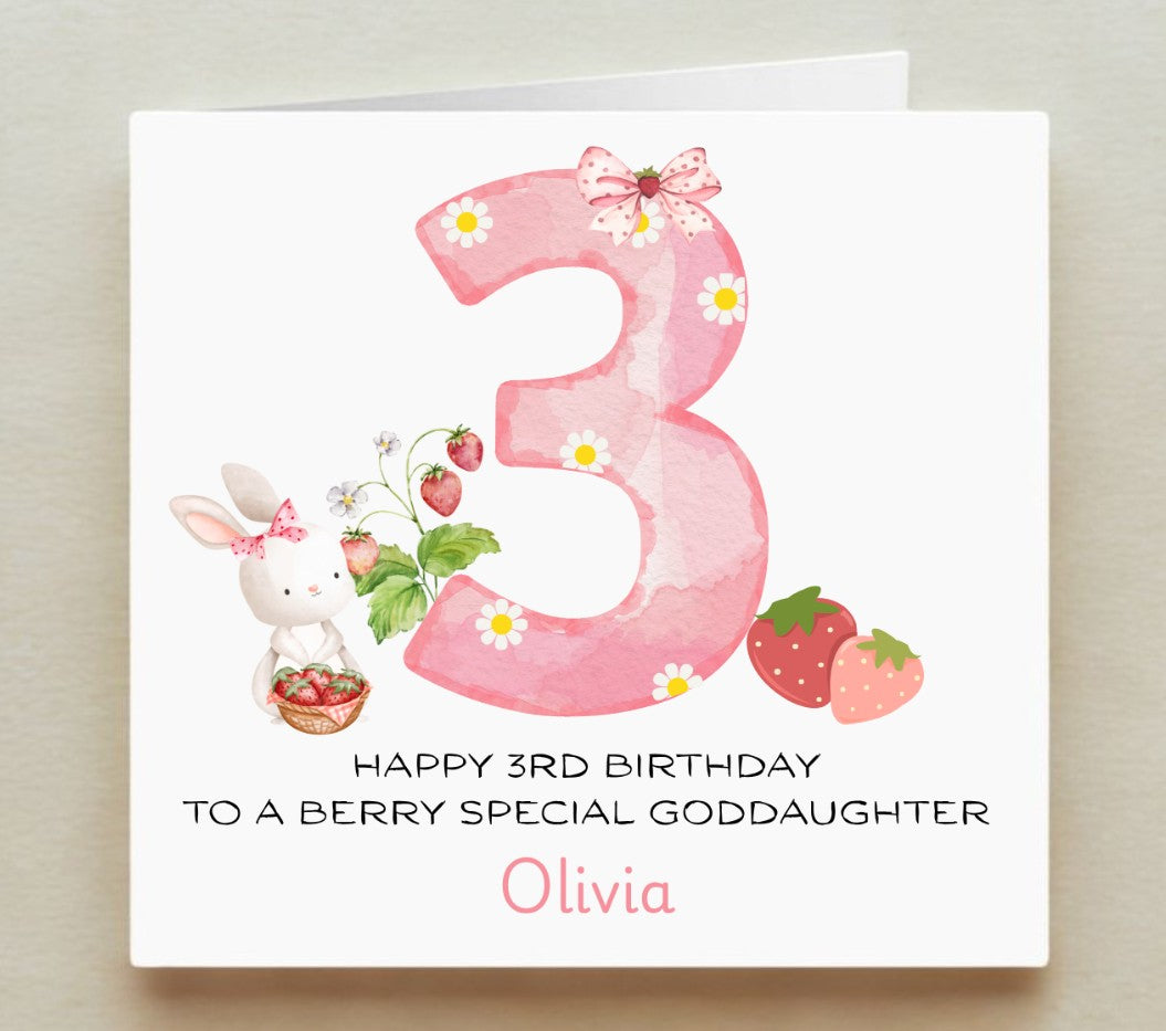 Happy 3rd birthday card for a goddaughter with a pink number 3, rabbit, and strawberries on a white background.